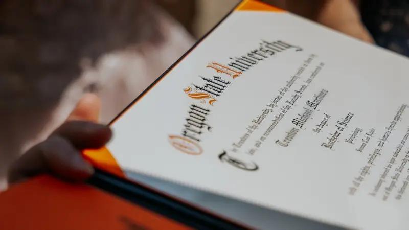 Título universitario con sello oficial y firmas académicas sobre documento de graduación